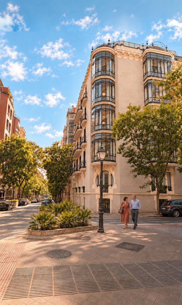 Pareja paseando junto a la esquina de Casa Ayala, con sus miradores y los árboles de la calle