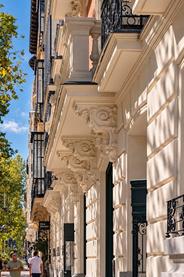 Fachadas señoriales con balcones y ménsulas a lo largo de una calle del Barrio de Salamanca
