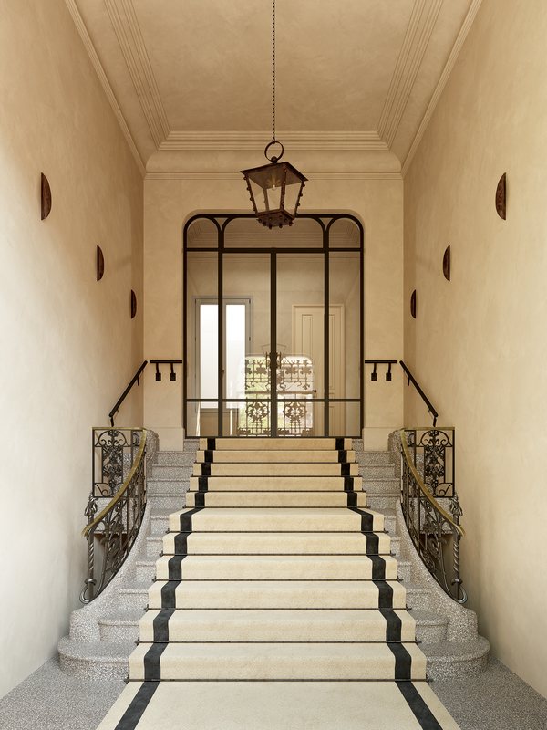 Hall principal de Casa Ayala con escalera de mármol y puerta acristalada de forja