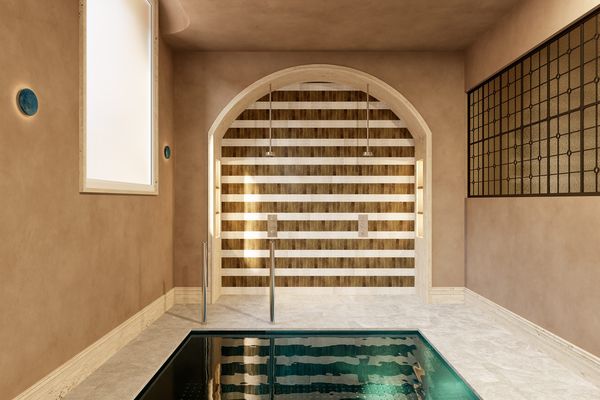 Piscina interior climatizada de Casa Ayala bajo un arco de piedra y celosía de madera